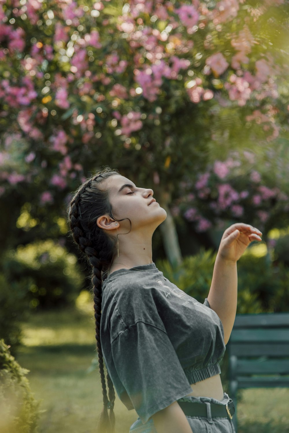 a woman with her hand on her face in front of a flowering tree