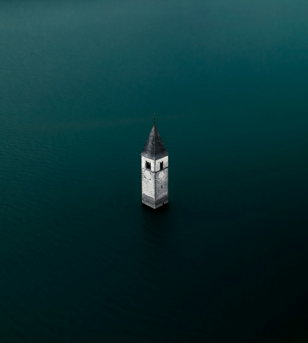 a small tower in the middle of the water