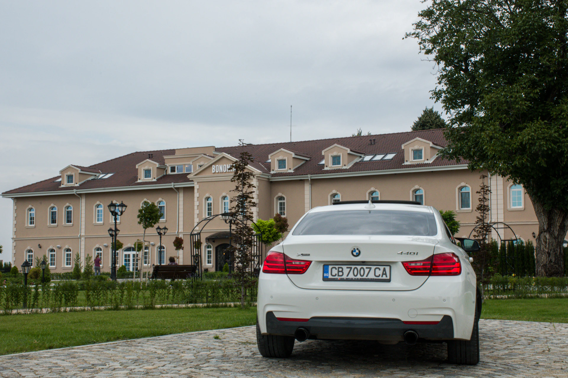 A shiny white BMW parked in front of a modern home, emphasizing luxury and style for potential buyers.