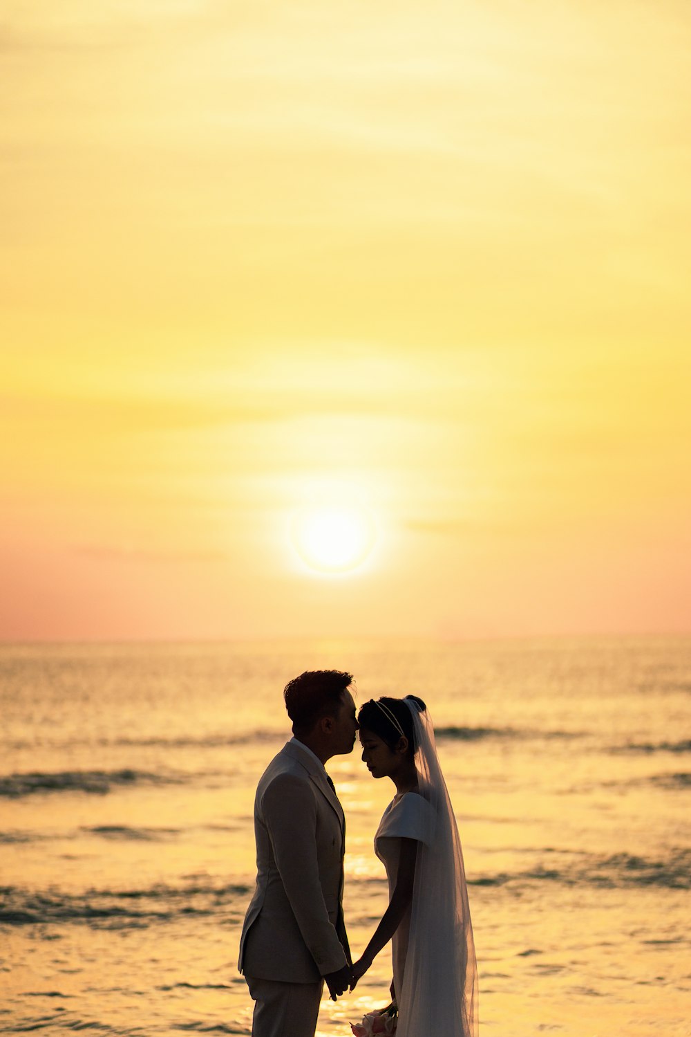 a man and woman holding hands on a beach