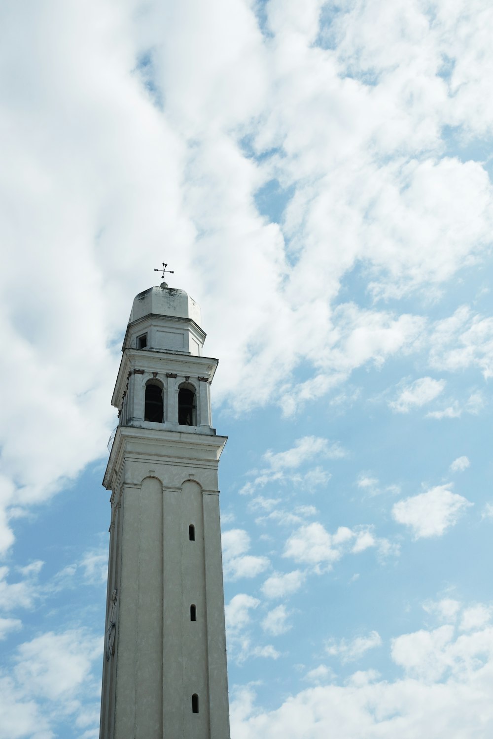 a tall white tower with a cross on top