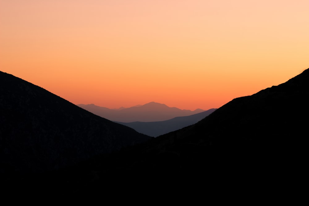 a landscape with hills and a sunset