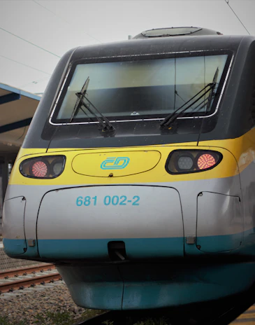 A contemporary regional train with clean lines and a graphite and silver color scheme, captured in a minimalist setting.