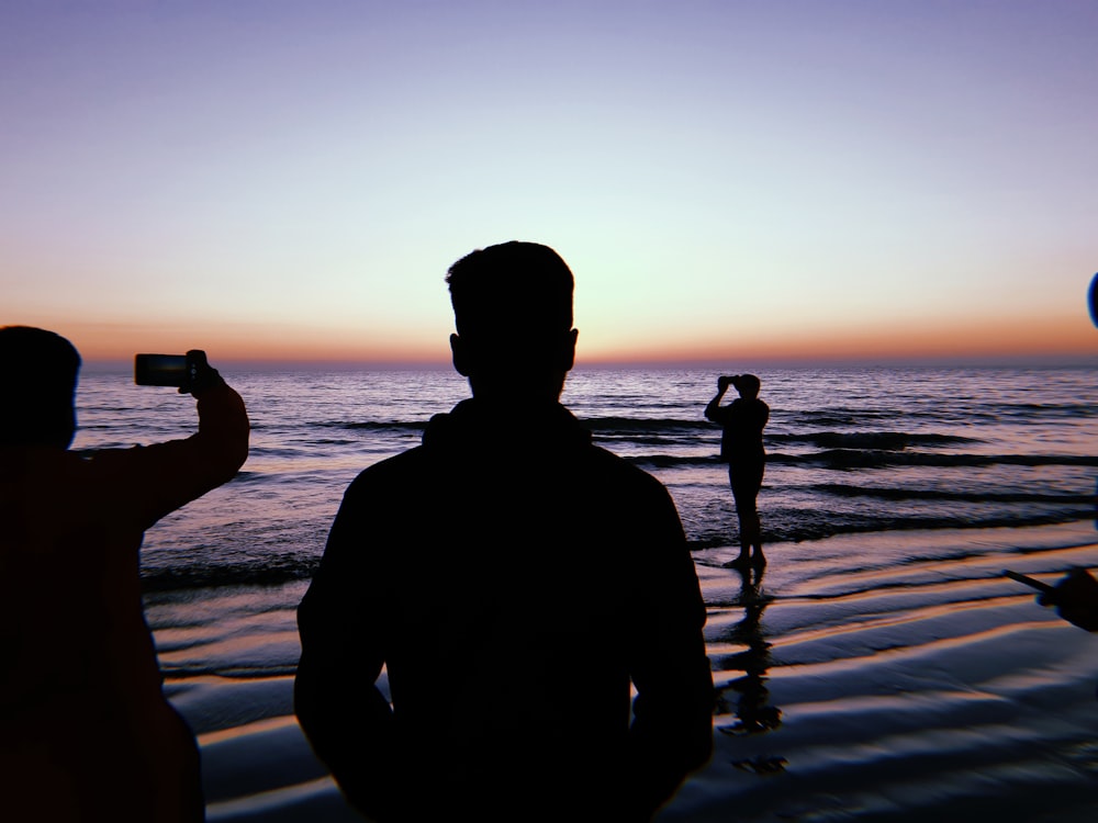 a group of people taking pictures at the beach