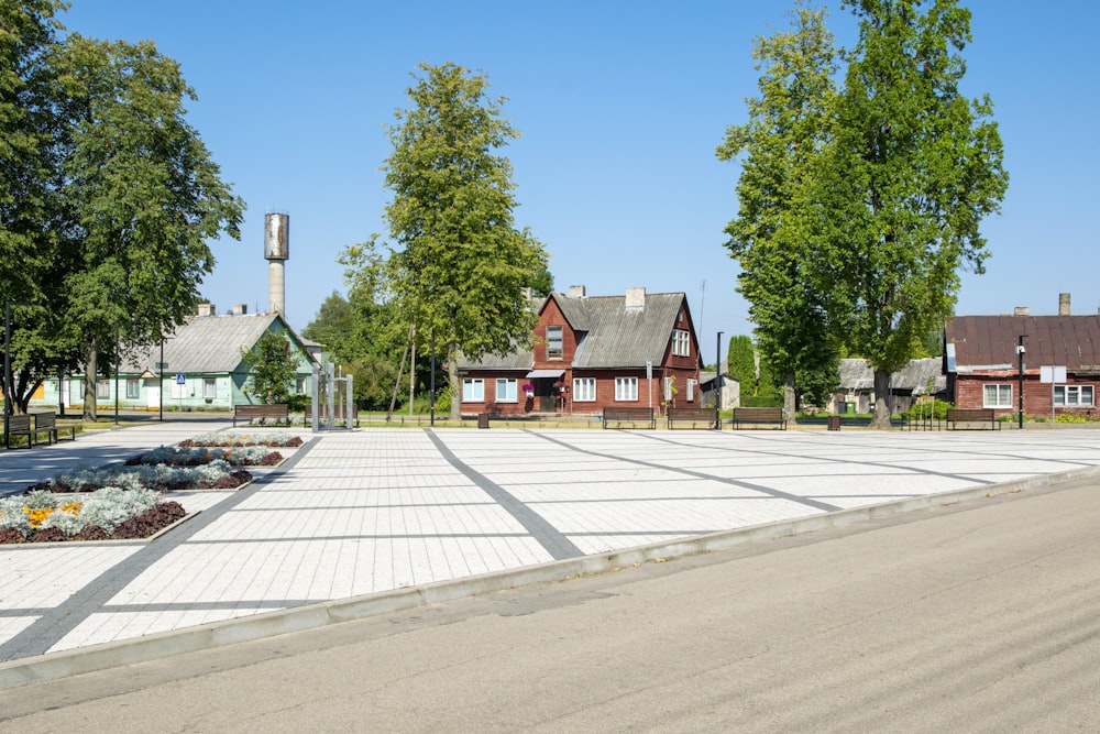 a paved area with trees and houses in the background