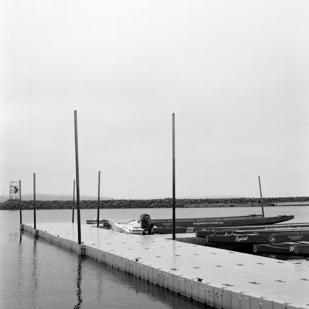 a person sitting on a dock next to a row of boats