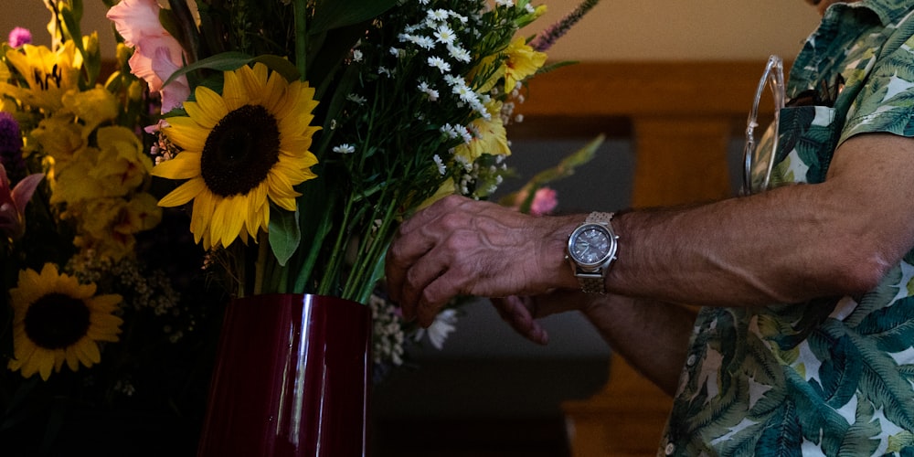 a man holding a vase of flowers