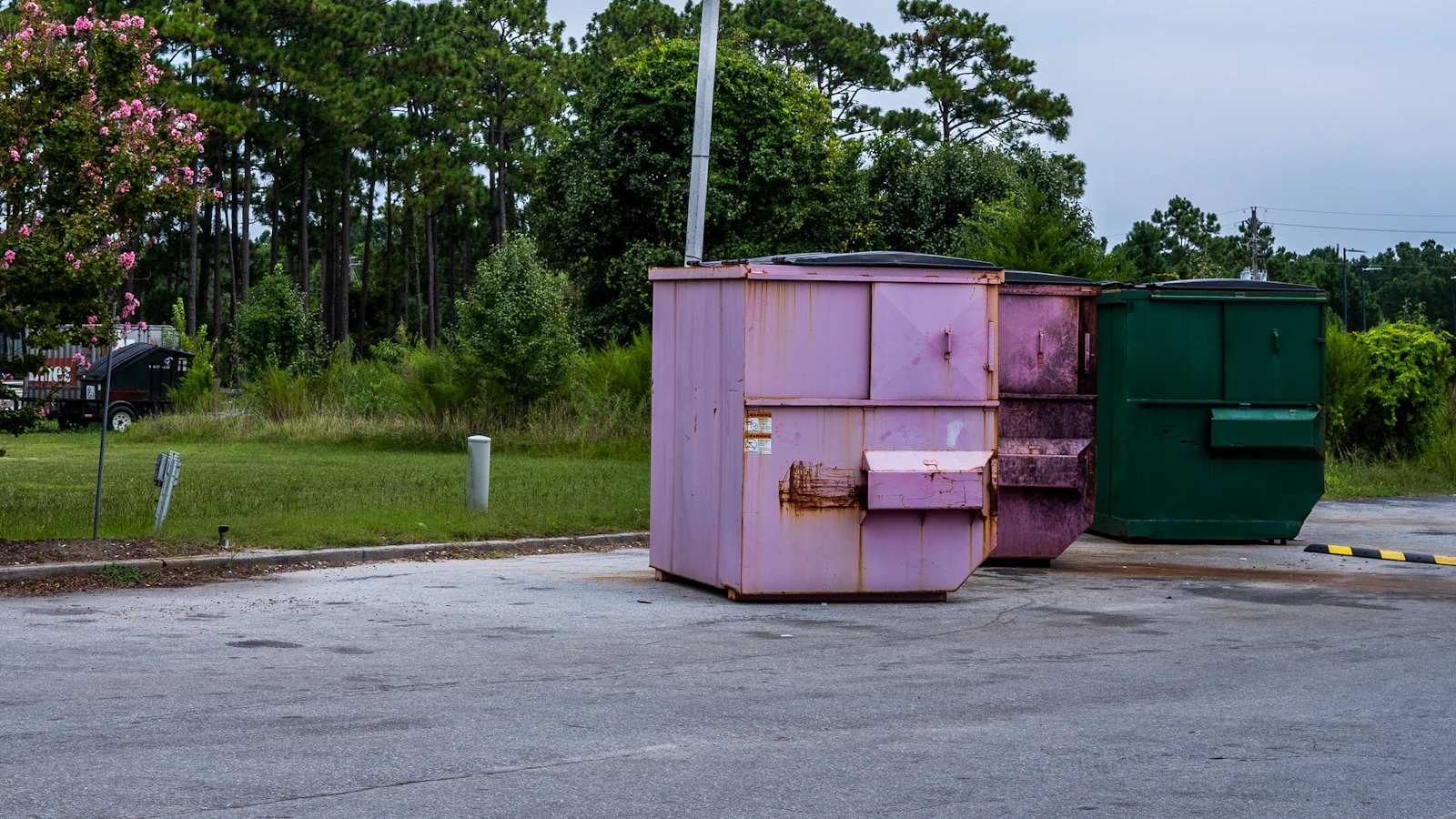 Row of real roll-off dumpsters staged at an industrial site in Miami Beach