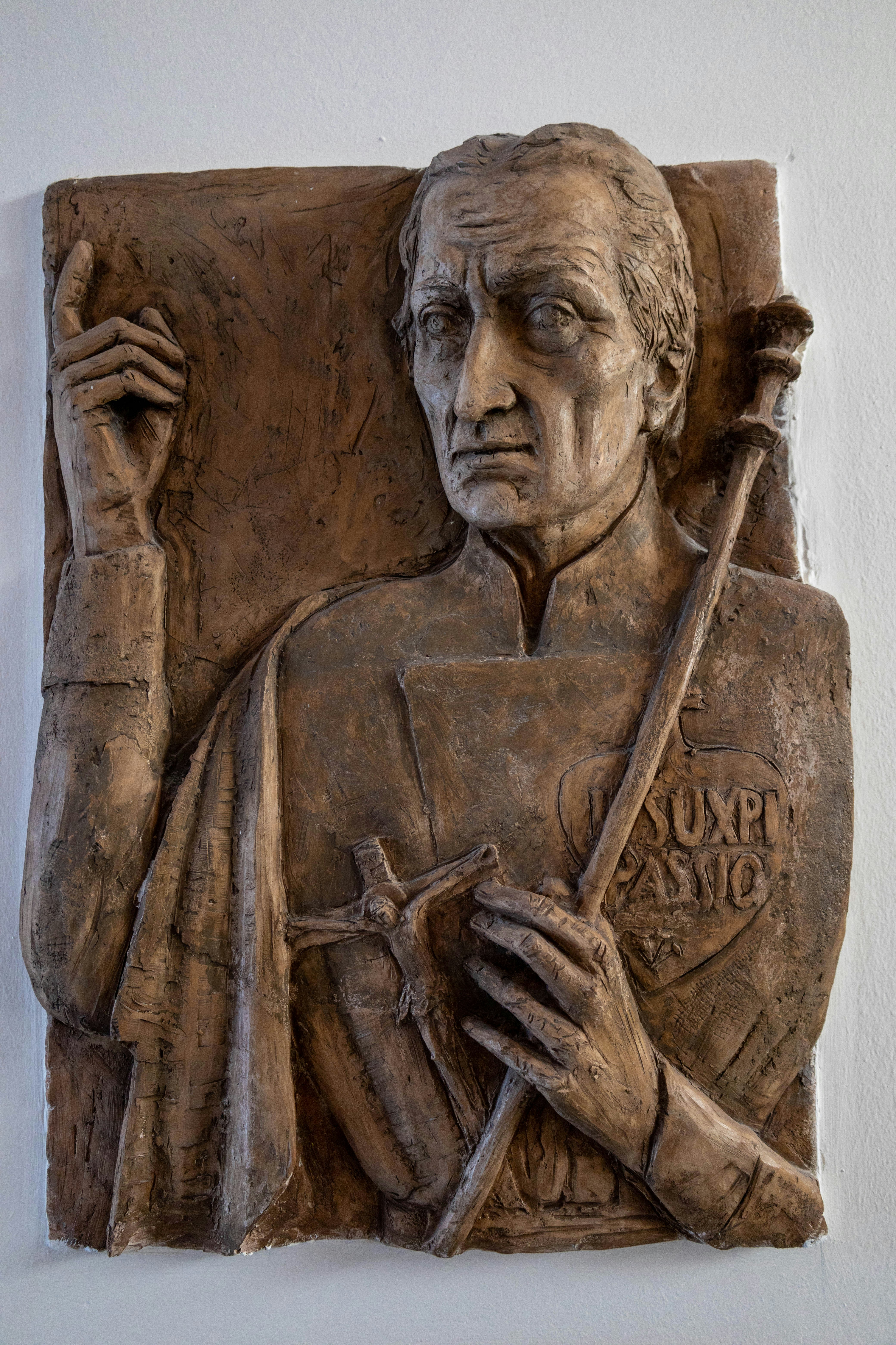 uma escultura em pedra de uma pessoa segurando um bastão