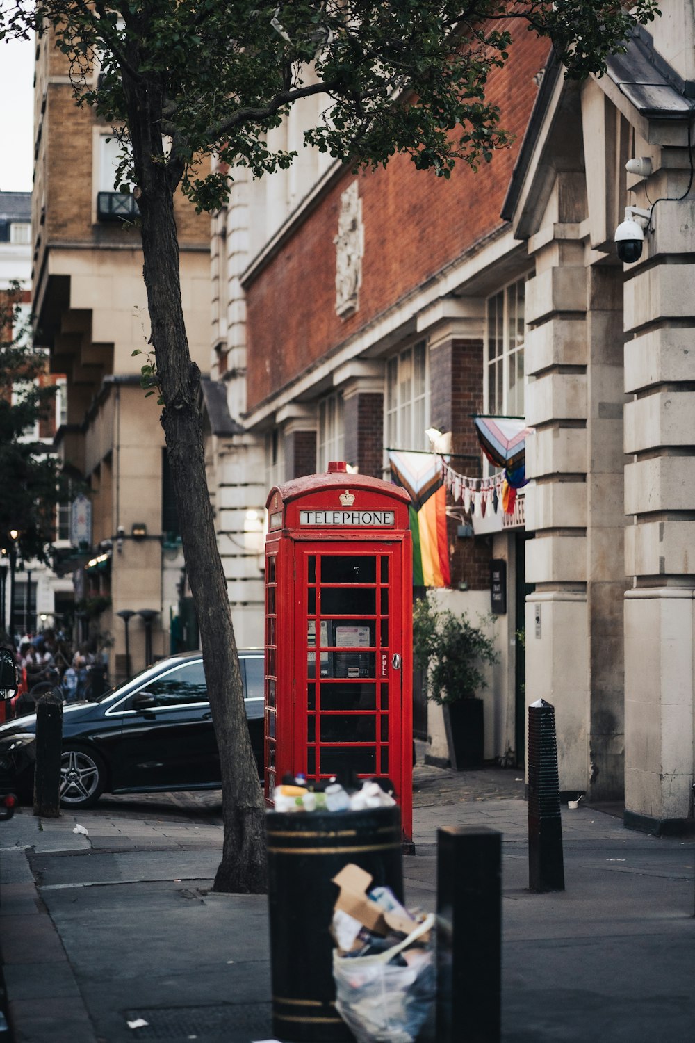 a red telephone booth on a sidewalk