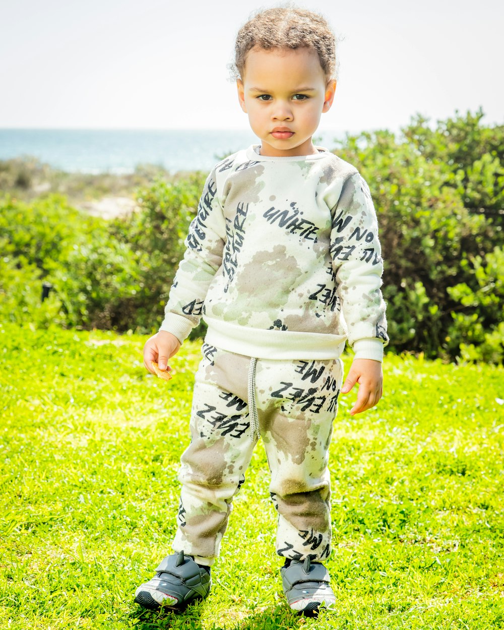 a child standing in a grassy area