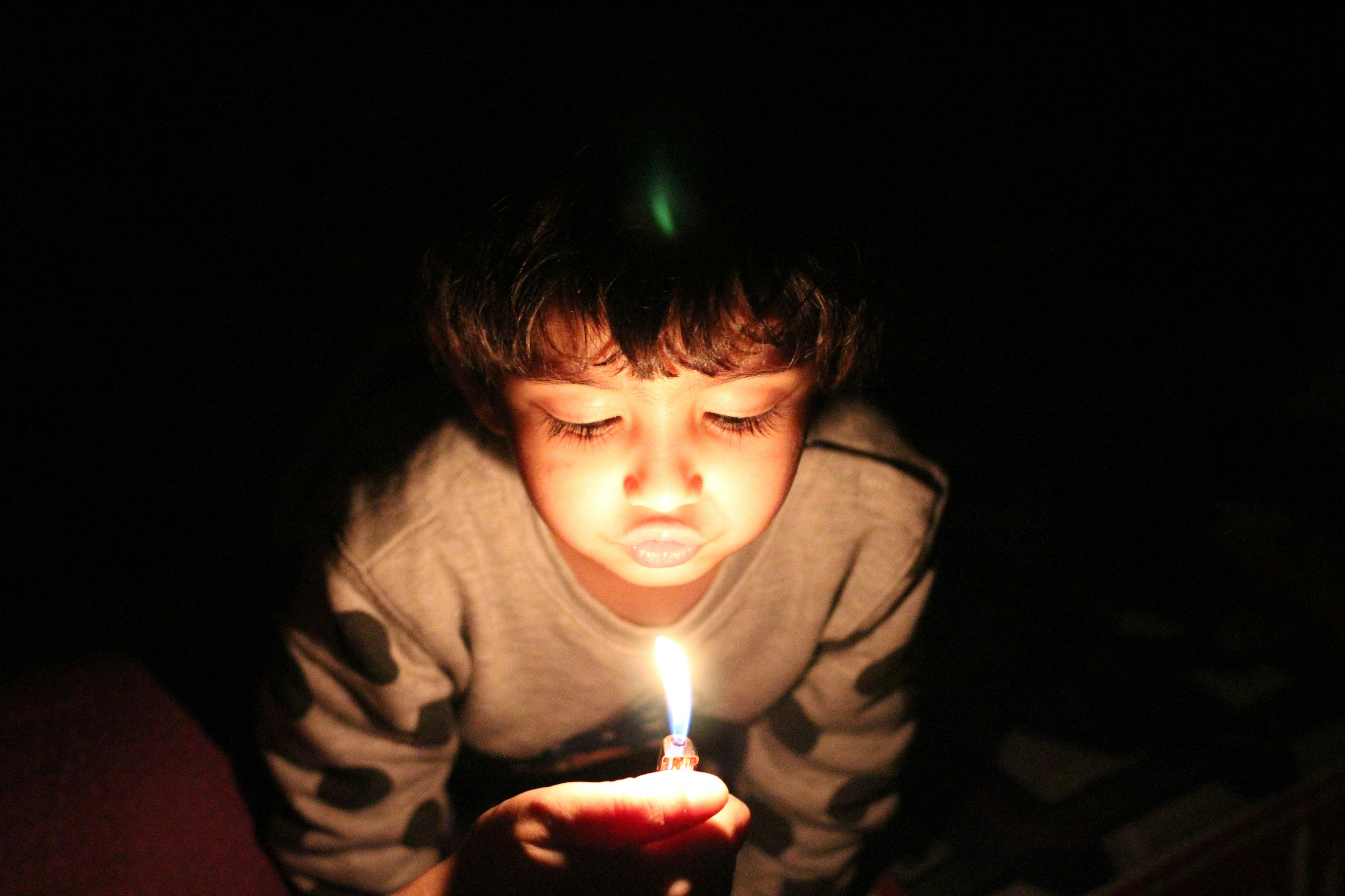 Child Pretending To Blow Out A Candle