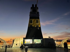 Security personnel patrolling a large cargo ship deck at sunset