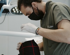 a man in a mask looking at a person in a stretcher