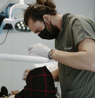 a man in a mask looking at a person in a stretcher