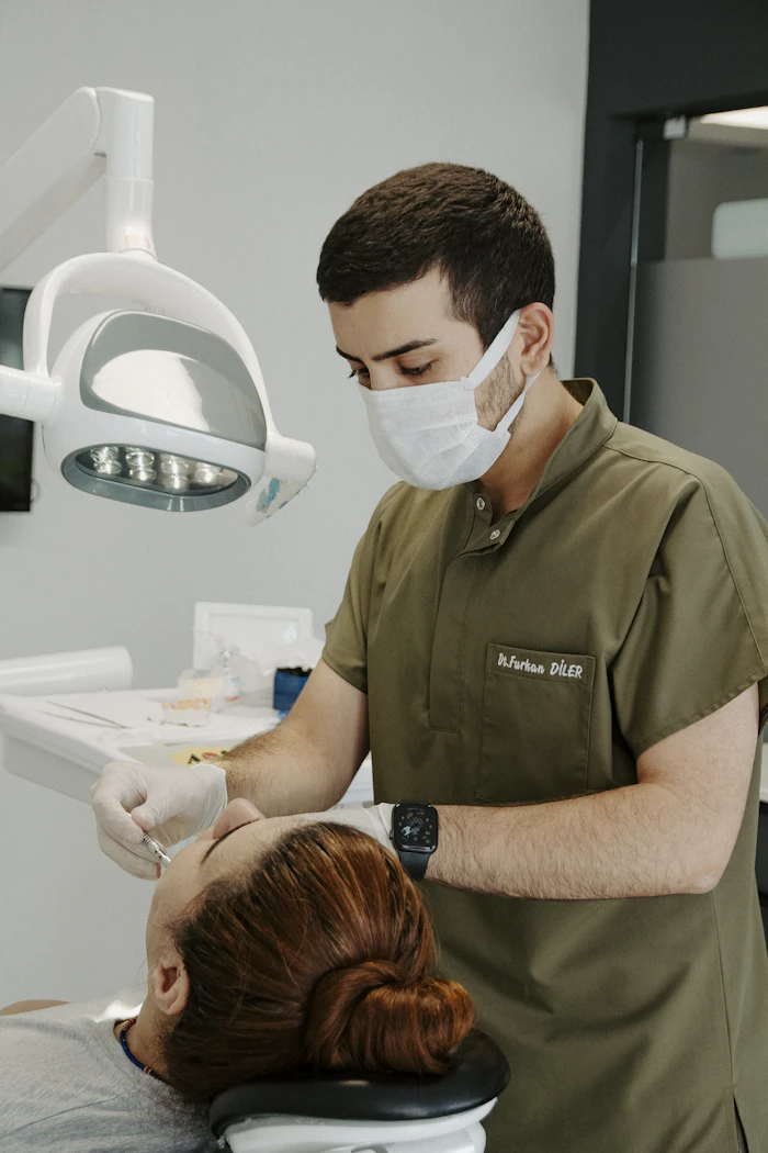 Dentist performing oral surgery on a patient at City Dental Fushë-Krujë