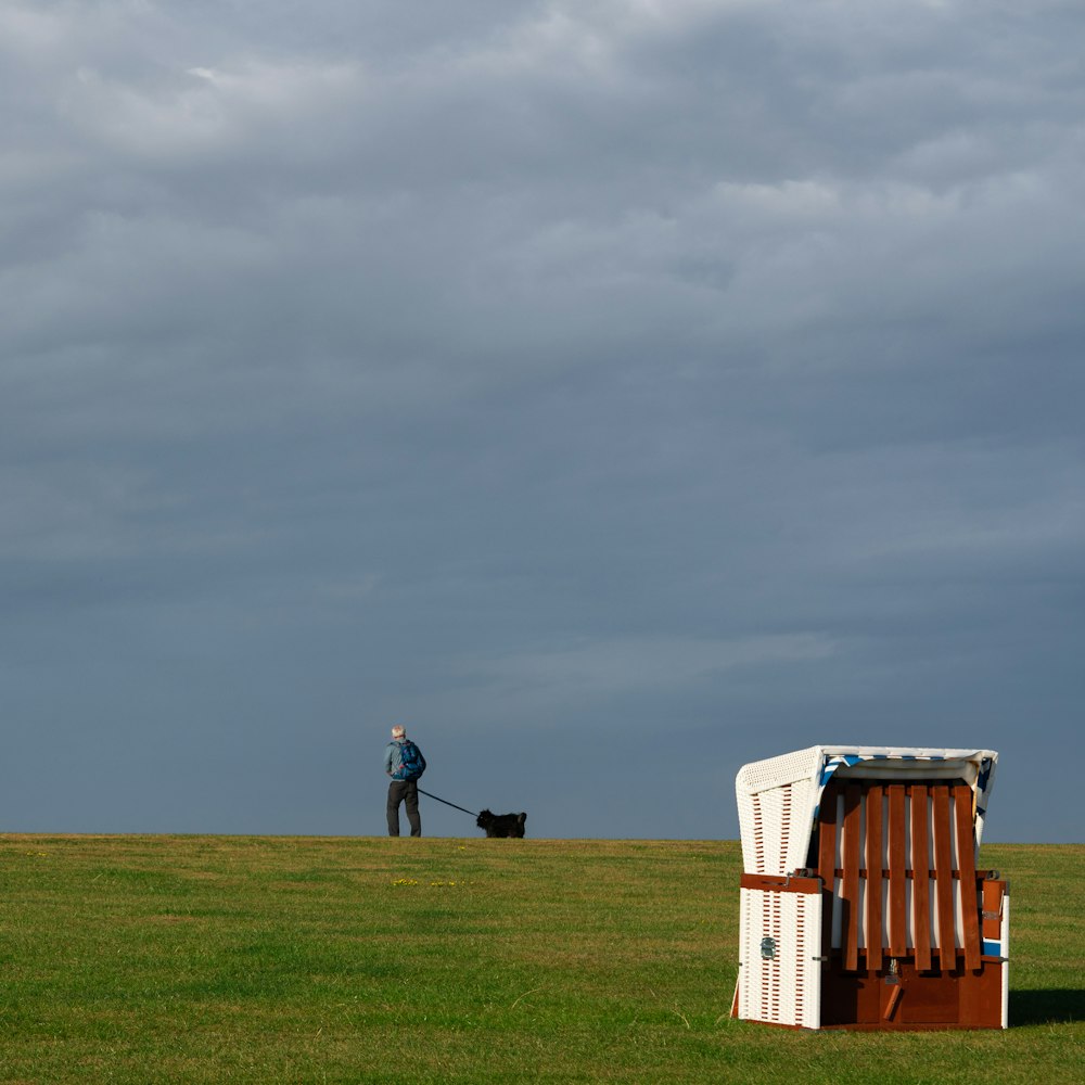 uma pessoa que passeia um cão em um campo de golfe