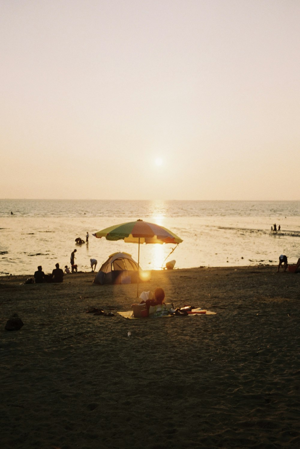 a beach with people and umbrellas