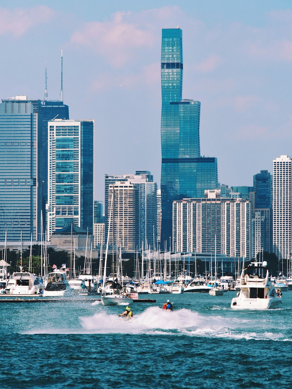 a group of boats in the water with a city in the background