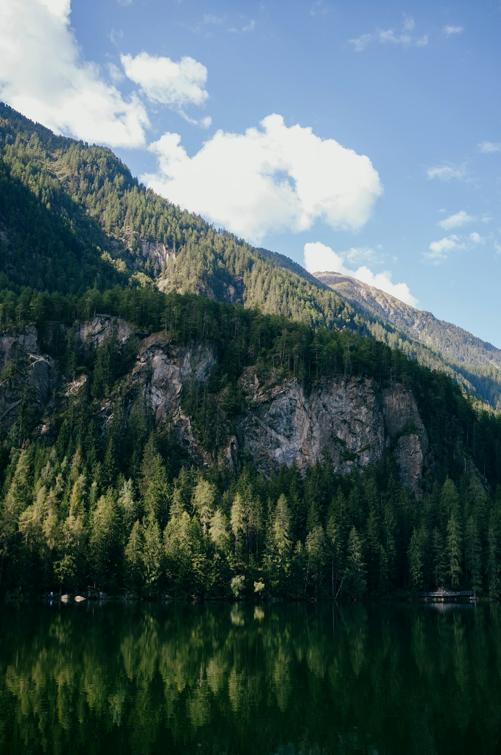 a lake with trees and mountains in the background