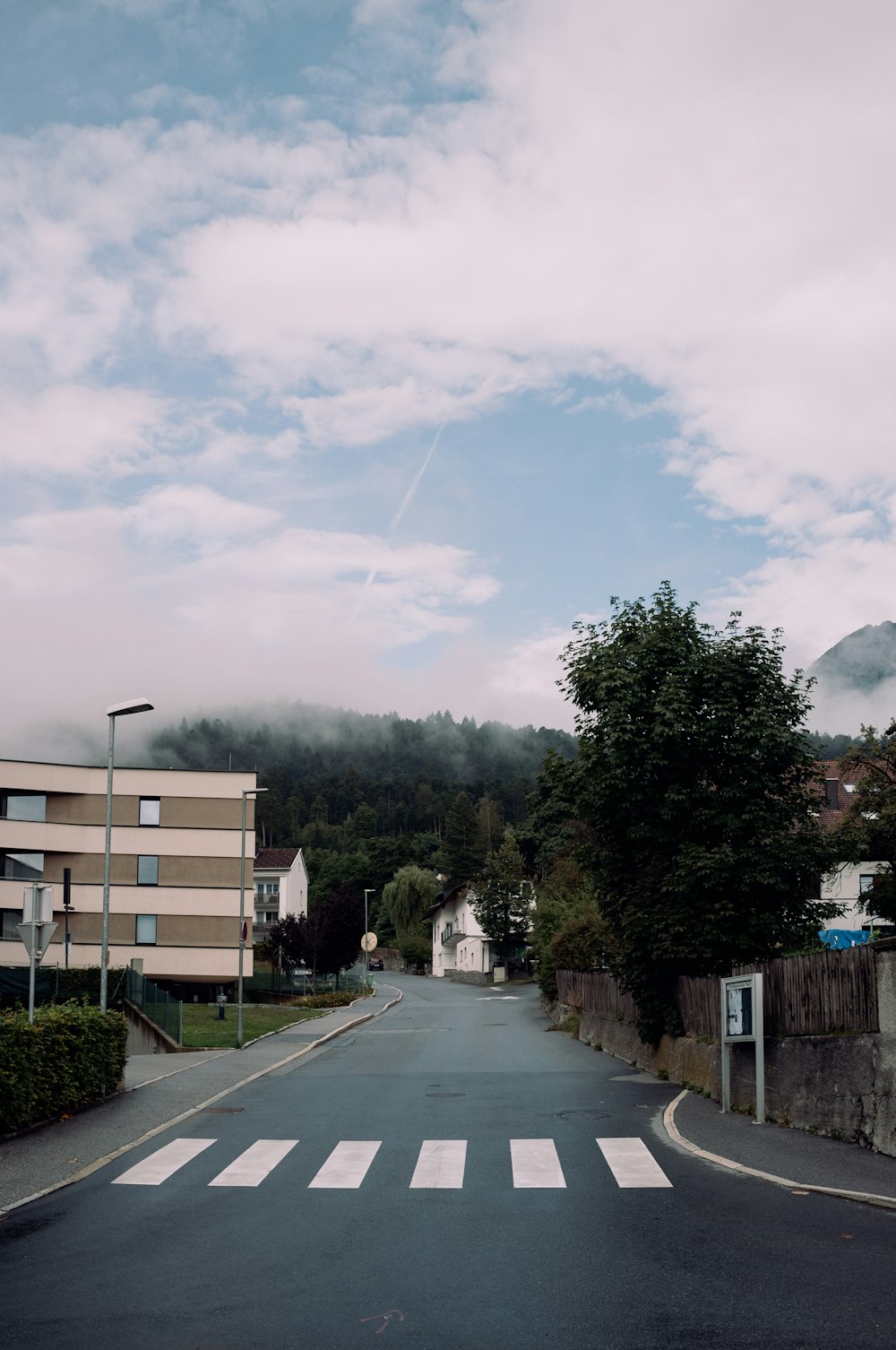 a street with trees and buildings on the side