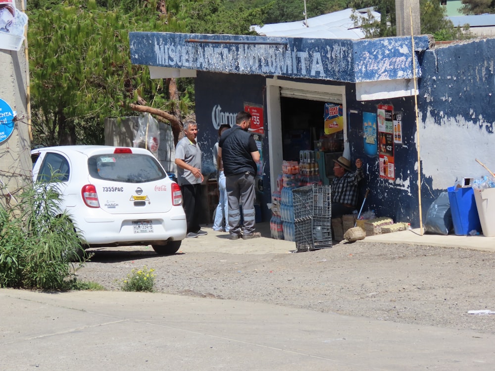 a group of men standing outside a small shop