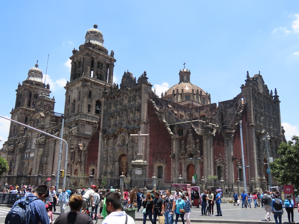 a large stone building with towers and a crowd of people in front