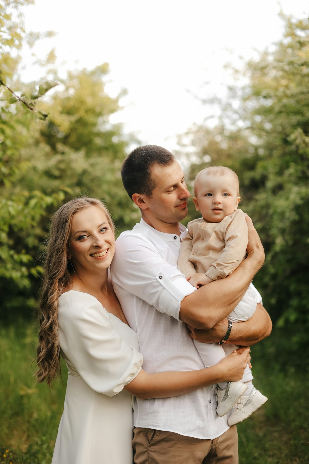 a man and woman holding a baby