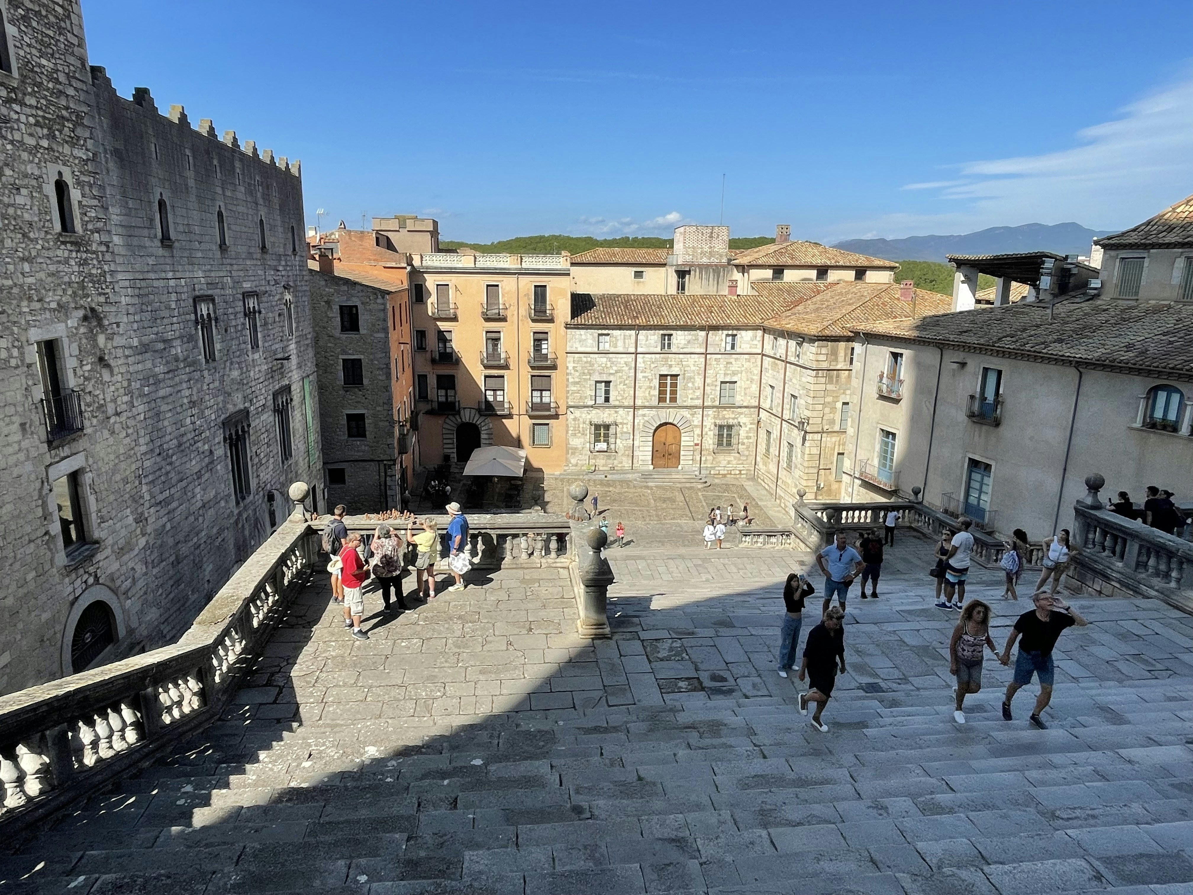 a group of people walking around a courtyard with buildings around it