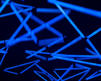 A collection of diverse 3D printed parts glowing subtly with blue and purple neon accents.