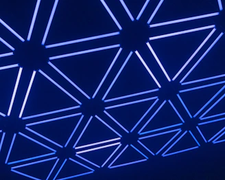 A glowing network grid spreading across a dark surface, representing the execution of reality.