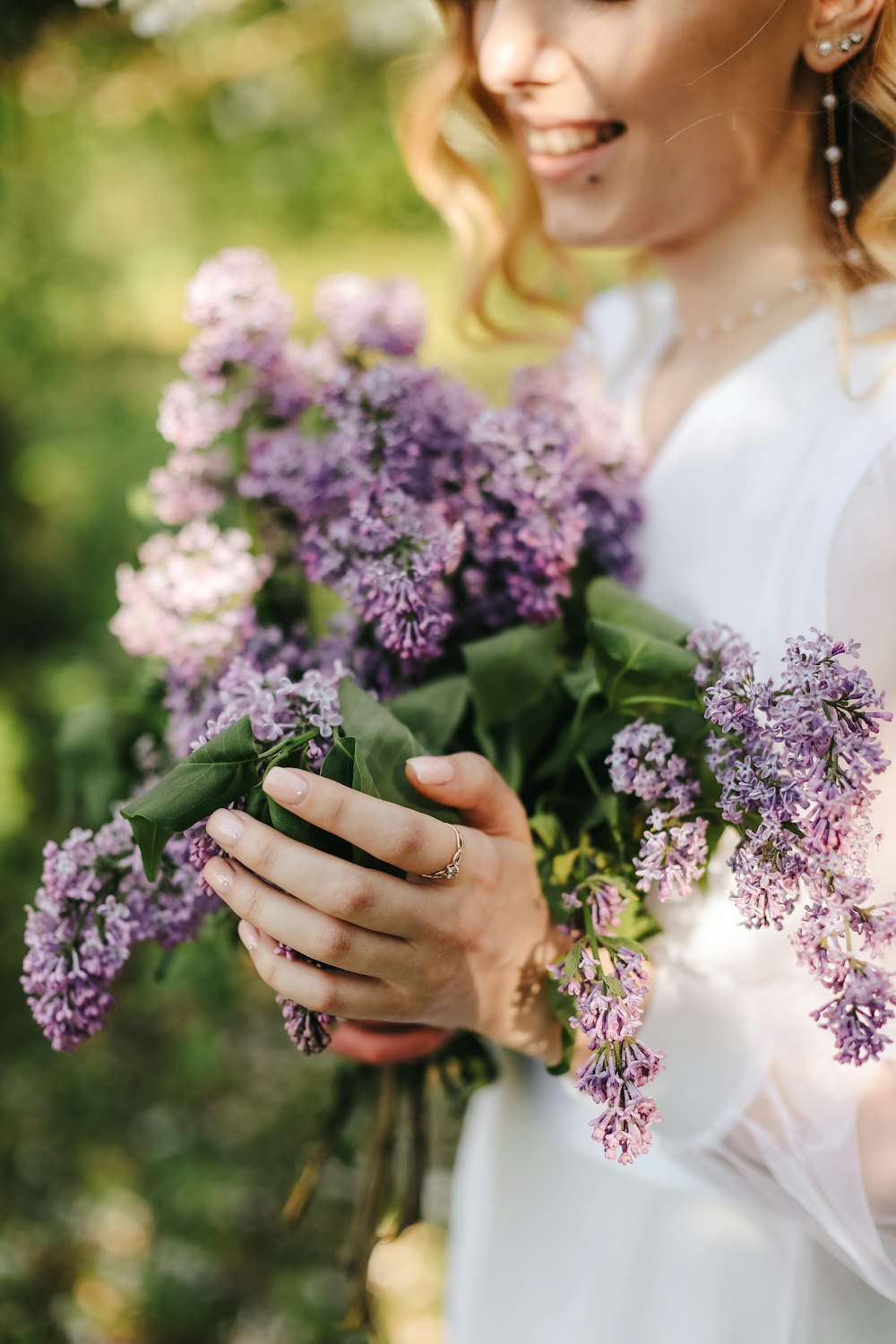 a woman holding a bouquet of purple flowers