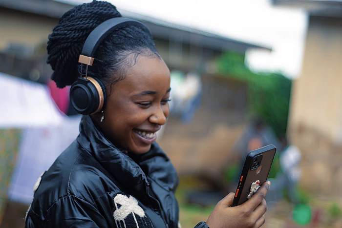 A person wearing headphones and holding a phone