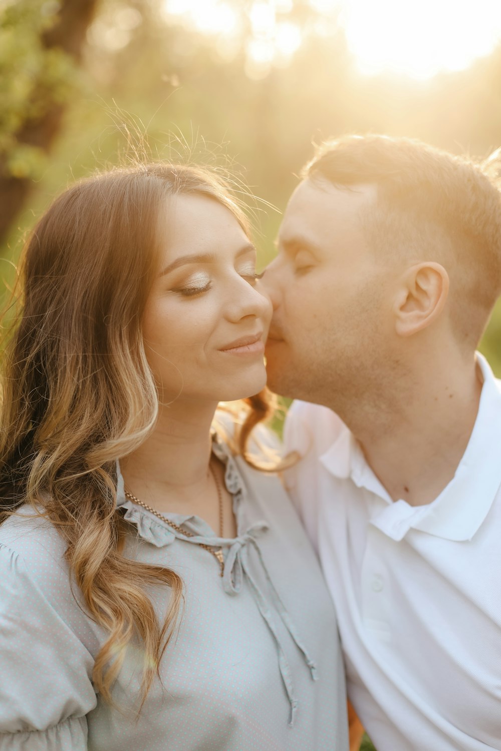 a man kissing a woman on the cheek