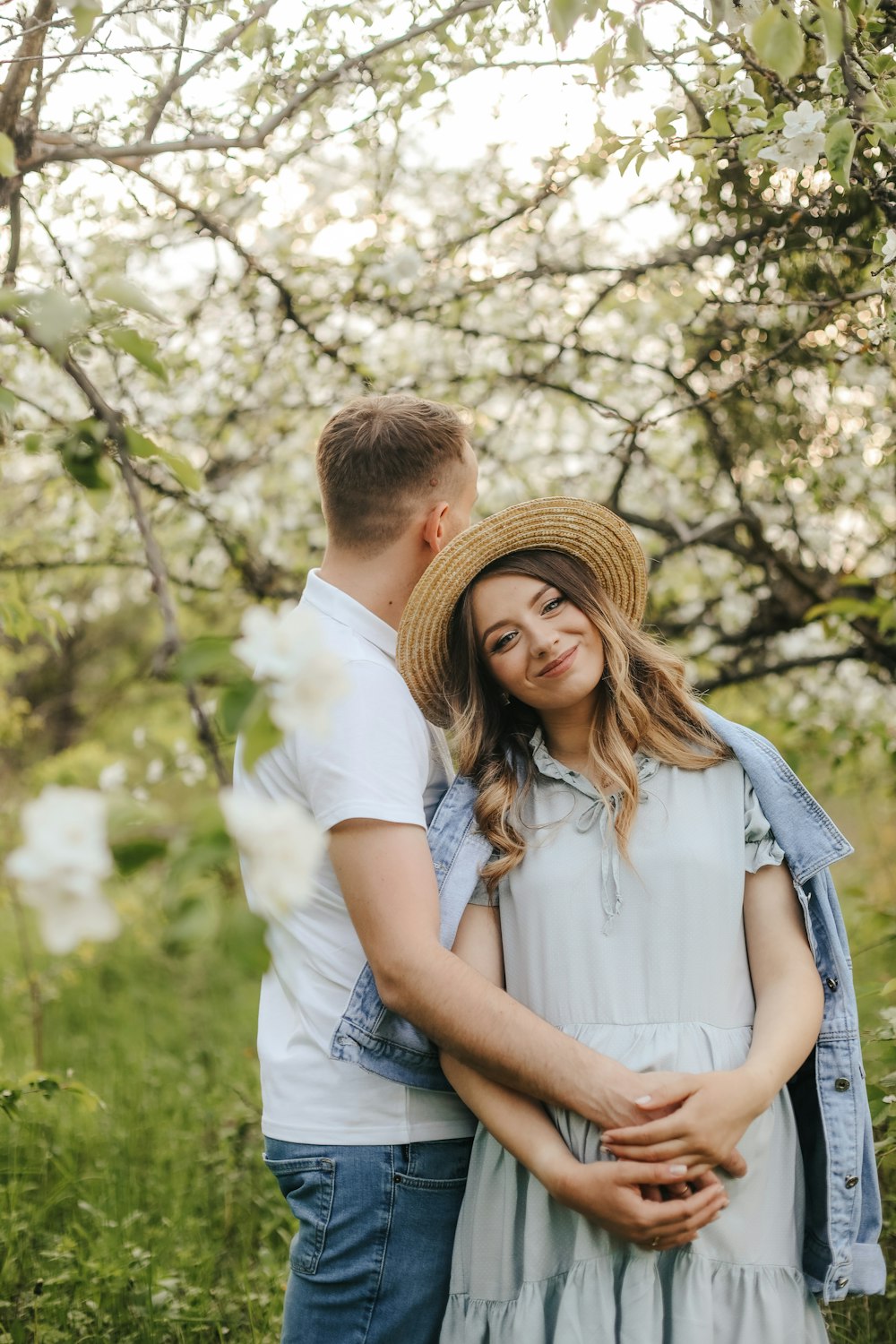 a man and woman standing under a tree