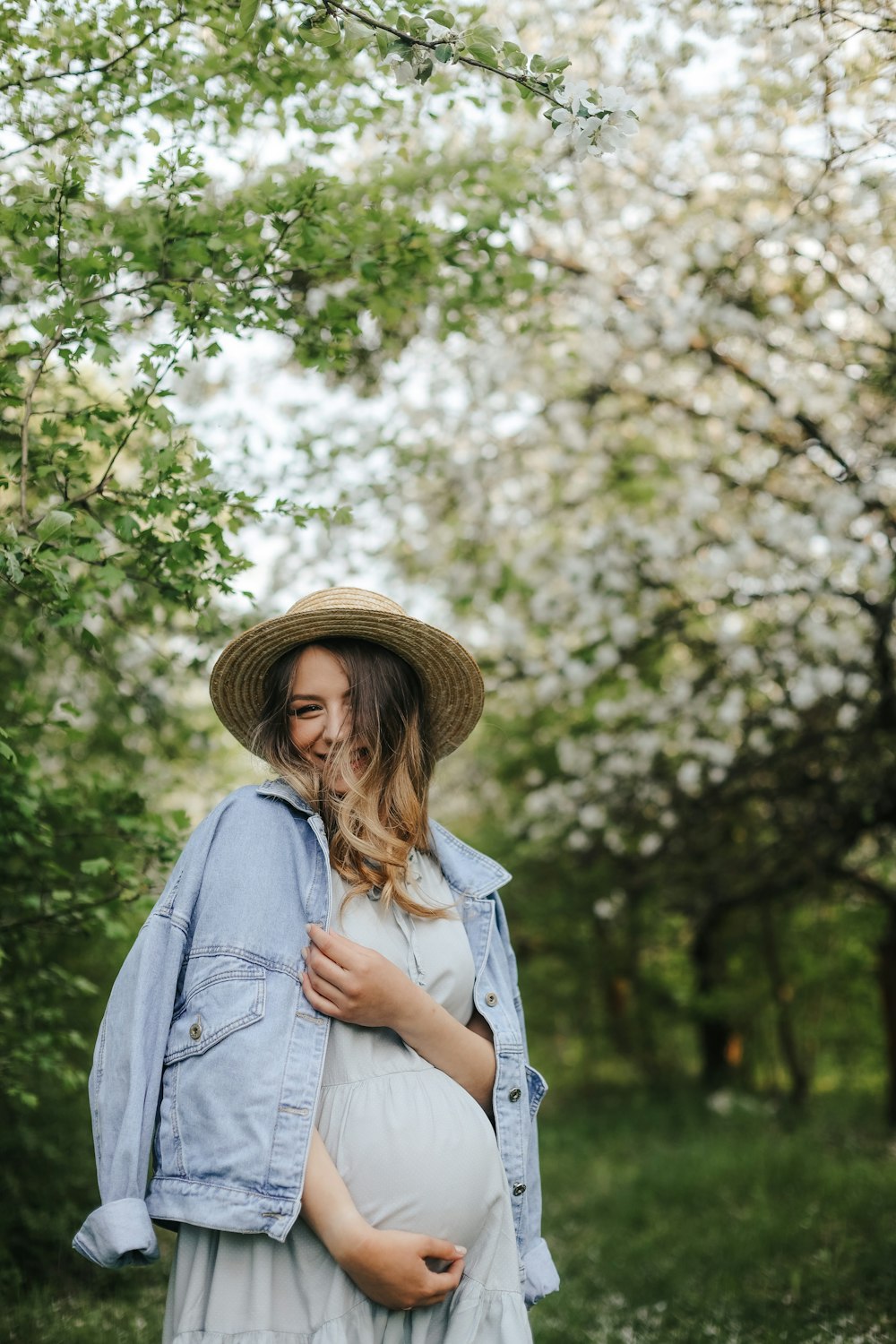 a person wearing a hat and standing next to a tree