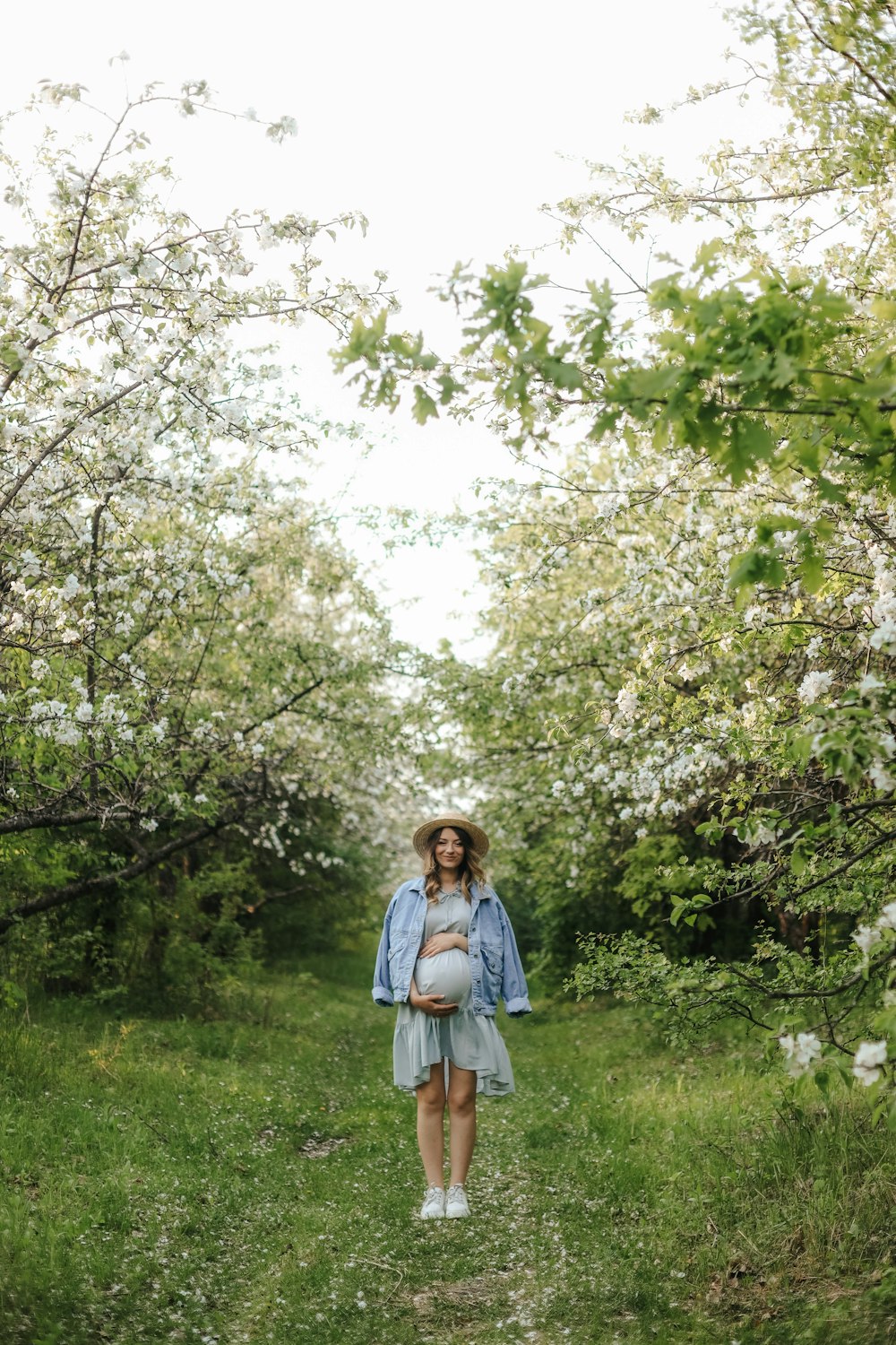 a person standing in a field of grass with trees in the back