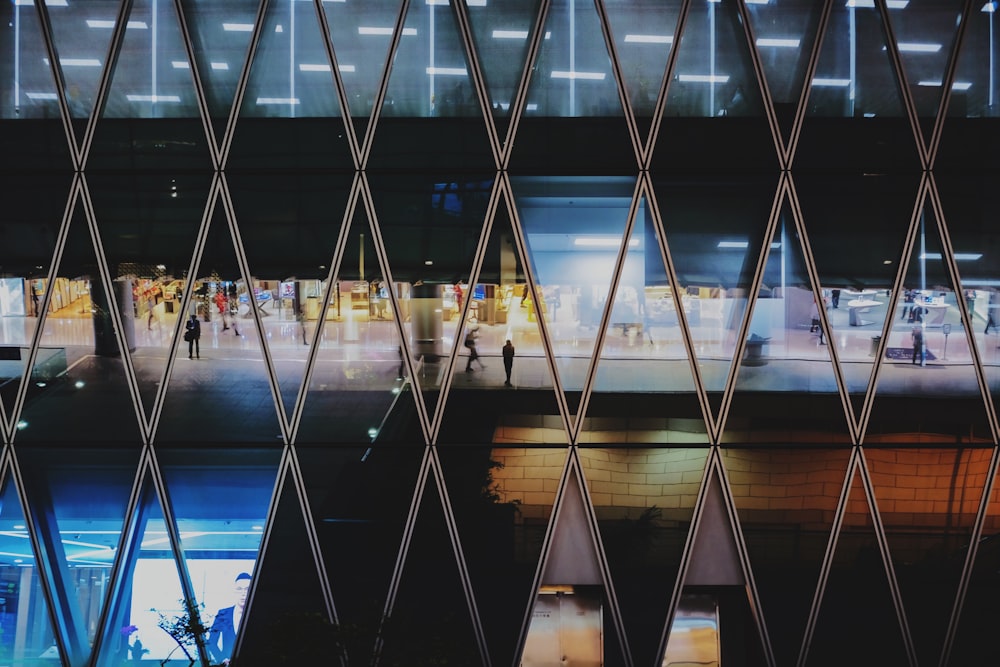 a large glass building with people walking around