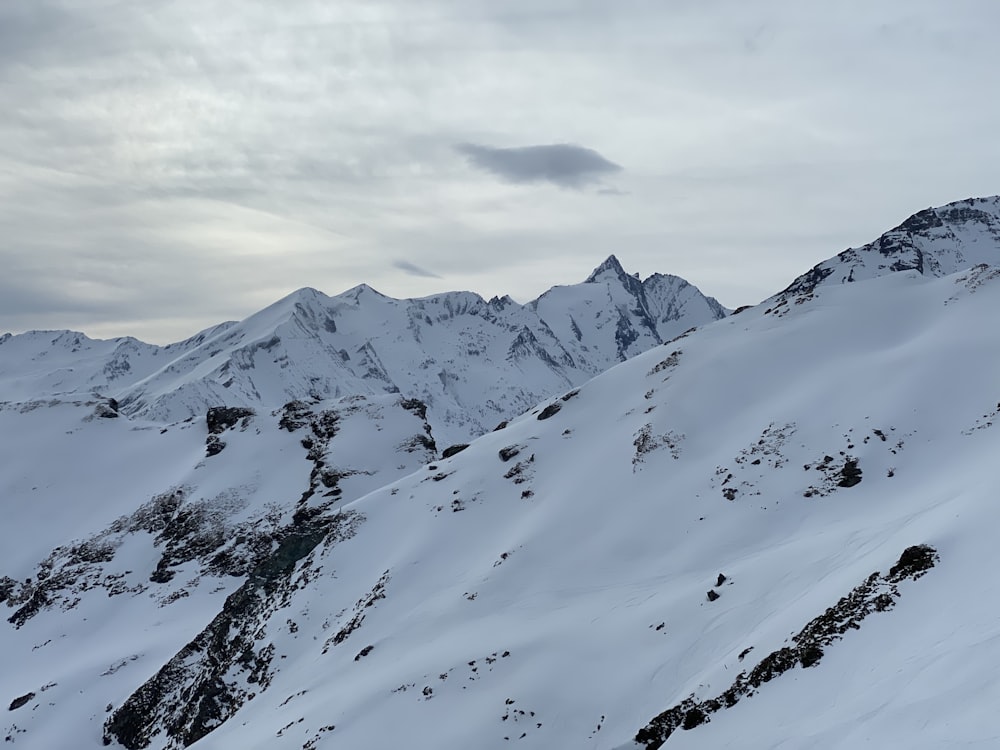 a snowy mountain with clouds