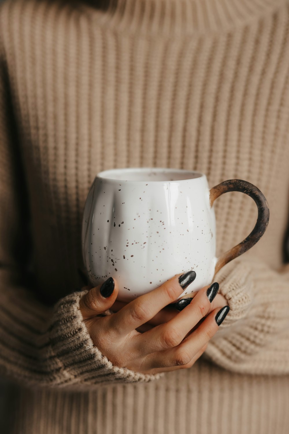 uma pessoa segurando uma xícara de café