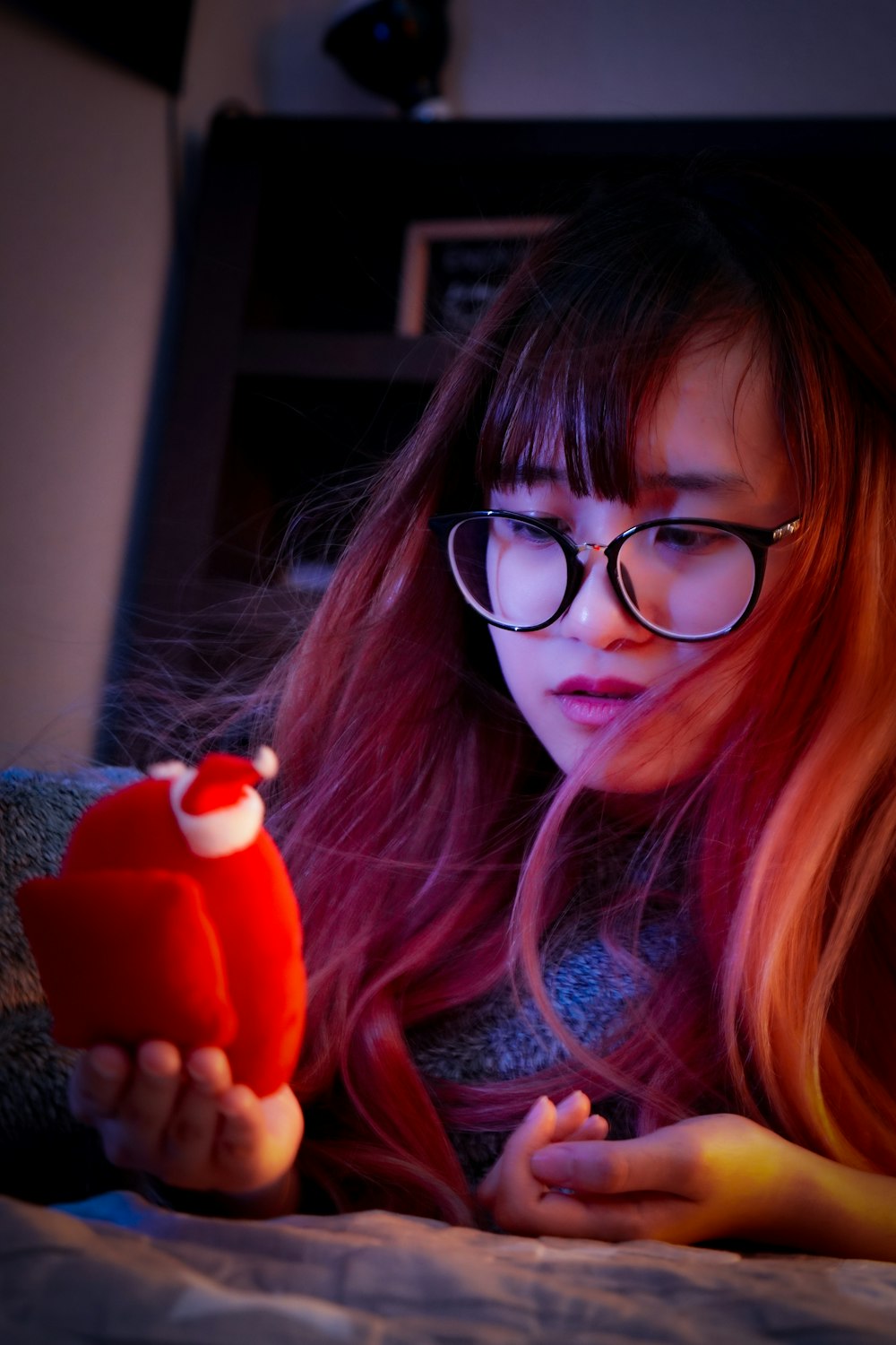 a girl with red hair holding a red toy