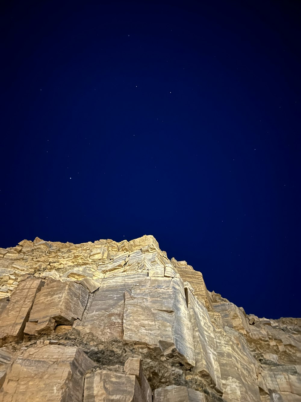 a rocky cliff with a blue sky