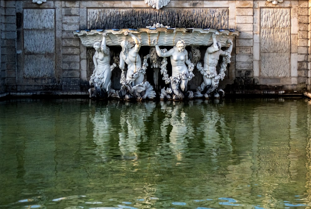 a fountain with statues in front of a building