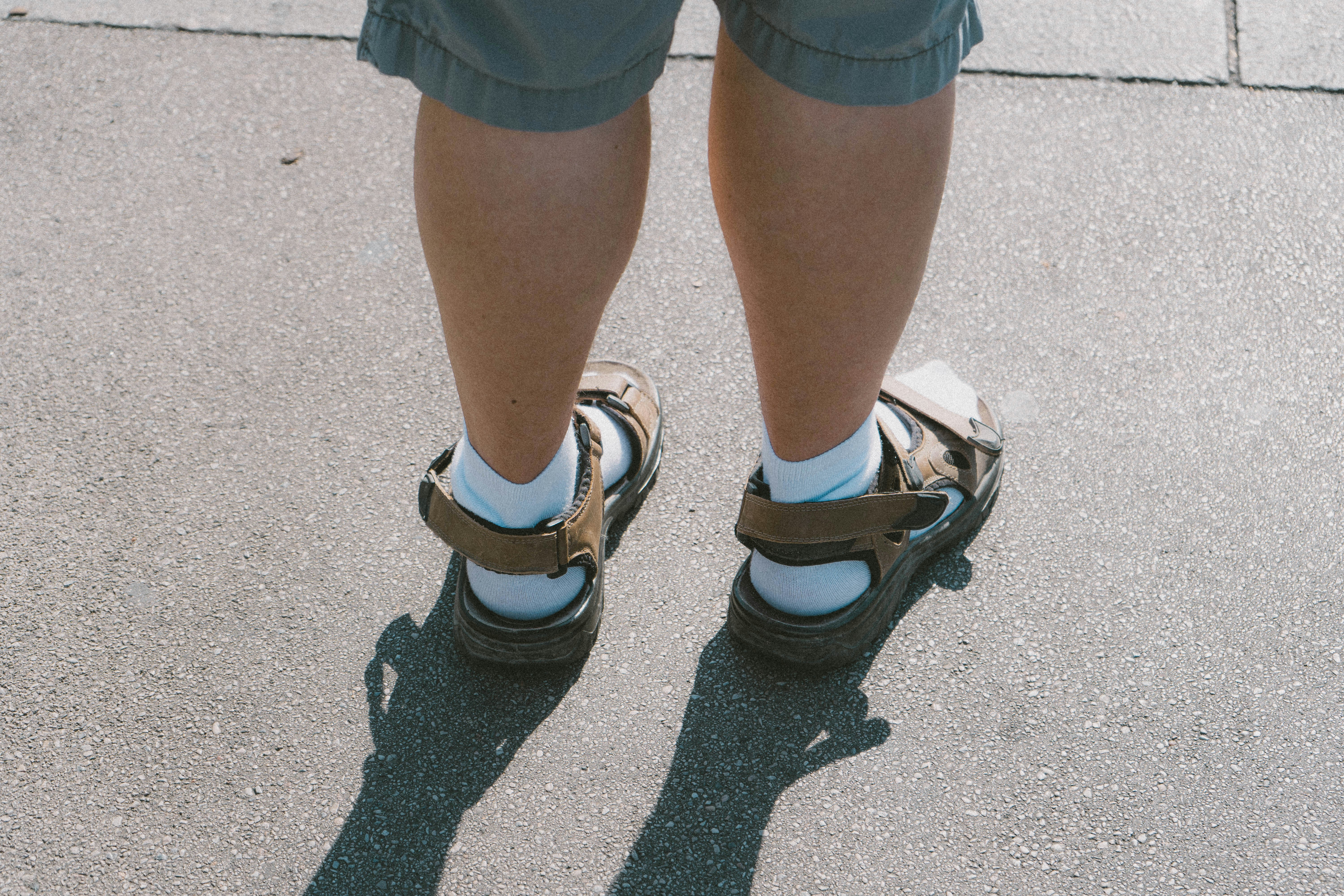 a pair of legs wearing sandals