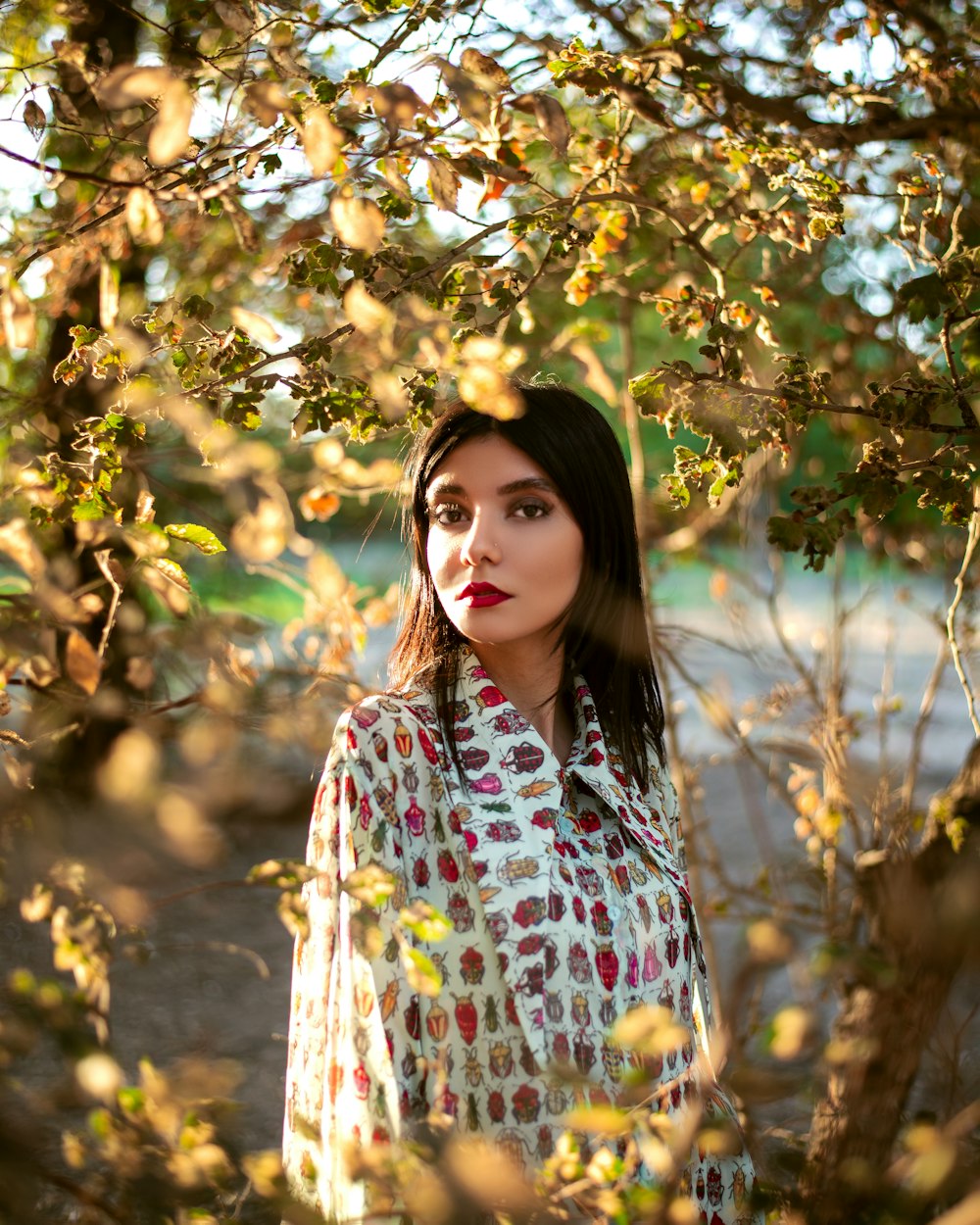 a woman standing under a tree