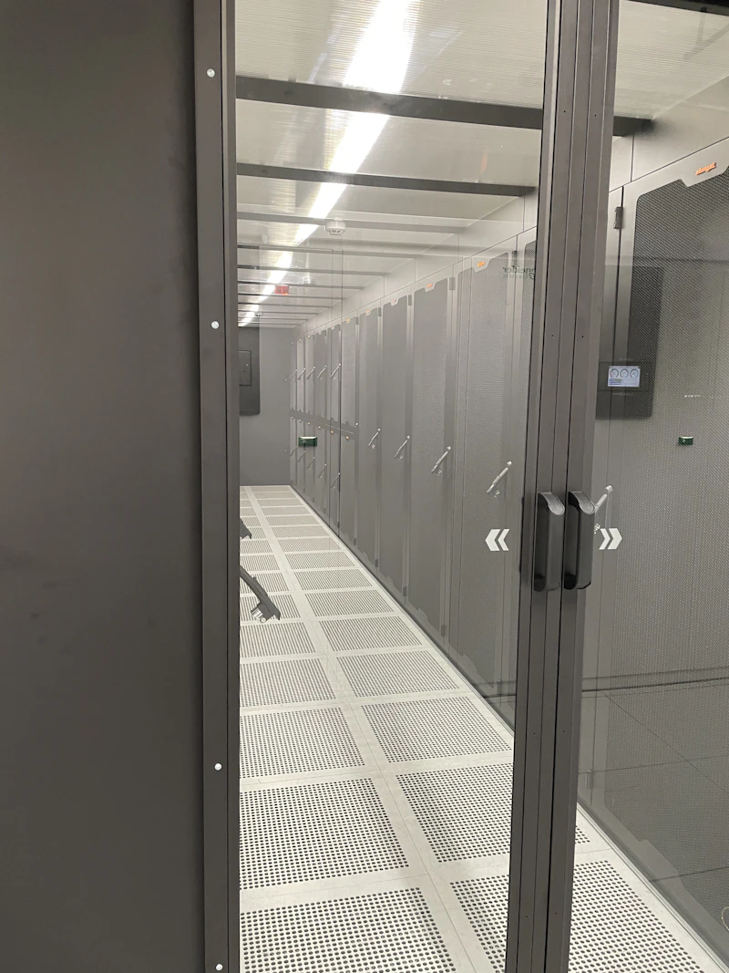 Server room aisle seen through a glass door