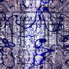 A complex and abstract composition featuring swirling and intertwining lines in shades of blue and black, overlaying a textured background of intricate, geometric patterns. The overall style is chaotic yet rhythmic, with layers of design creating a sense of depth.