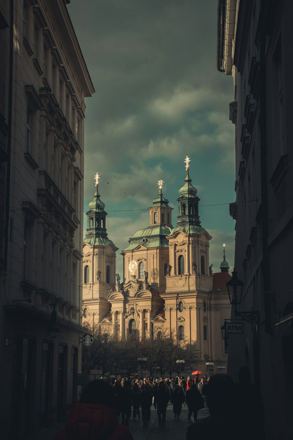 a group of people walking on a street between buildings