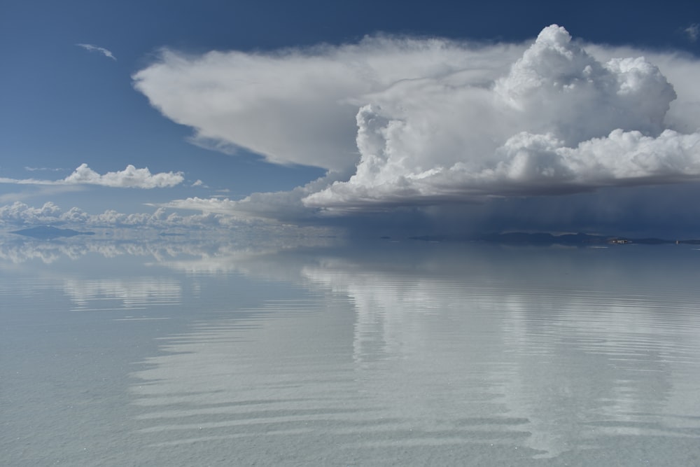 a body of water with clouds above it