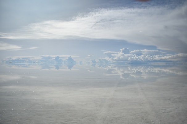 The stunning Uyuni Salt Flats under a clear blue sky reflecting the clouds.